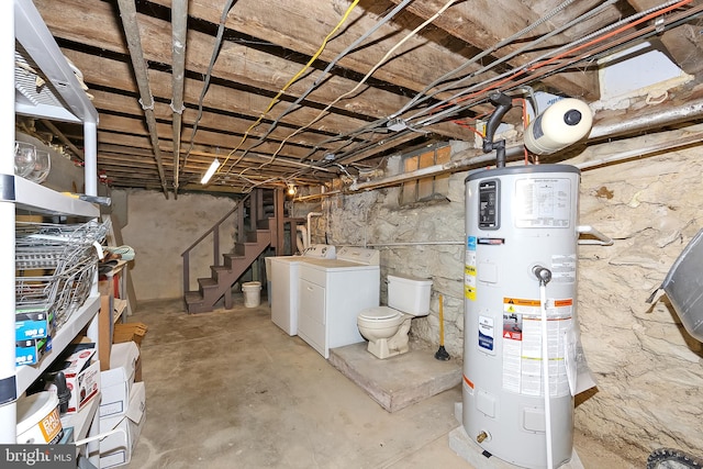 basement featuring heat pump water heater and washer and clothes dryer