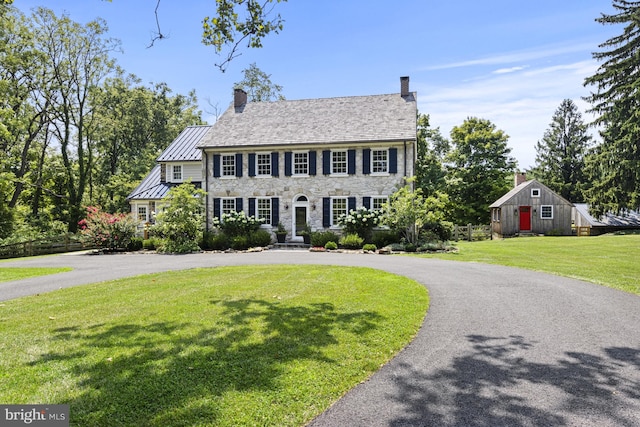 colonial home featuring a front lawn