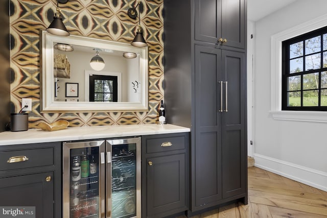 bar featuring gray cabinets, light parquet floors, tasteful backsplash, and wine cooler