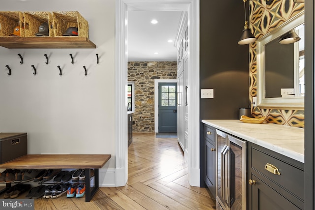 mudroom with light parquet floors and wine cooler