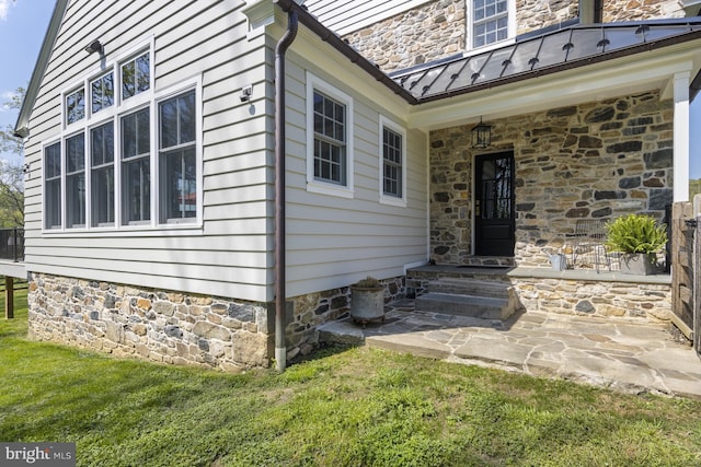 doorway to property with a lawn