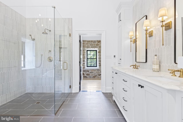 bathroom featuring tile patterned floors, walk in shower, and double vanity