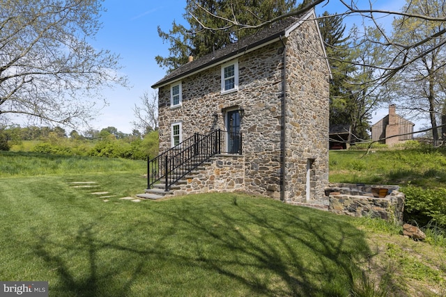 rear view of house featuring a yard