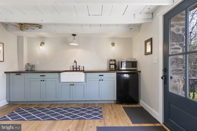 bar with black dishwasher, a healthy amount of sunlight, and light wood-type flooring