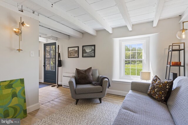 living room featuring beam ceiling and light hardwood / wood-style floors