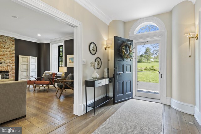 foyer entrance featuring ornamental molding and wood-type flooring