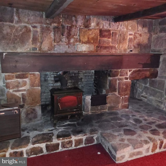 interior details with beam ceiling and a wood stove