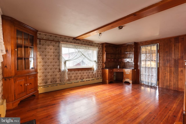 unfurnished living room featuring hardwood / wood-style flooring, beam ceiling, a baseboard heating unit, and wood walls