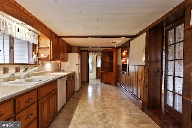 kitchen with light tile patterned flooring, beam ceiling, plenty of natural light, and white appliances