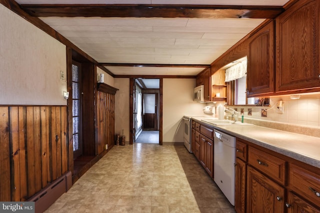 kitchen with tasteful backsplash, white appliances, sink, light tile patterned floors, and beam ceiling