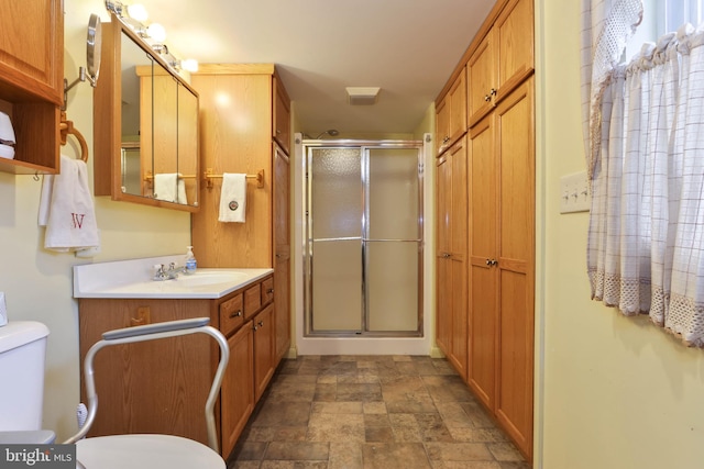 bathroom featuring tile patterned flooring, walk in shower, toilet, and vanity