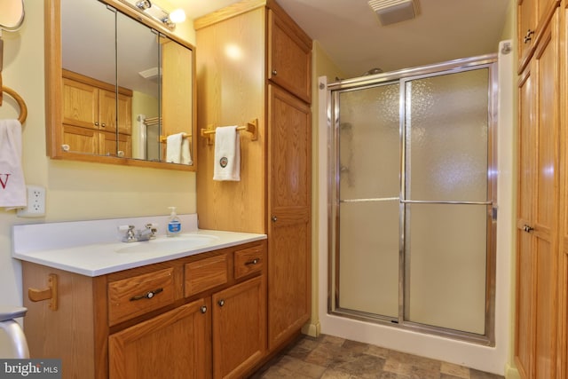 bathroom featuring tile patterned flooring, a shower with shower door, and vanity