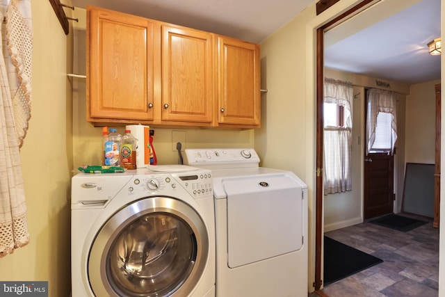 clothes washing area with cabinets, dark tile patterned flooring, and independent washer and dryer