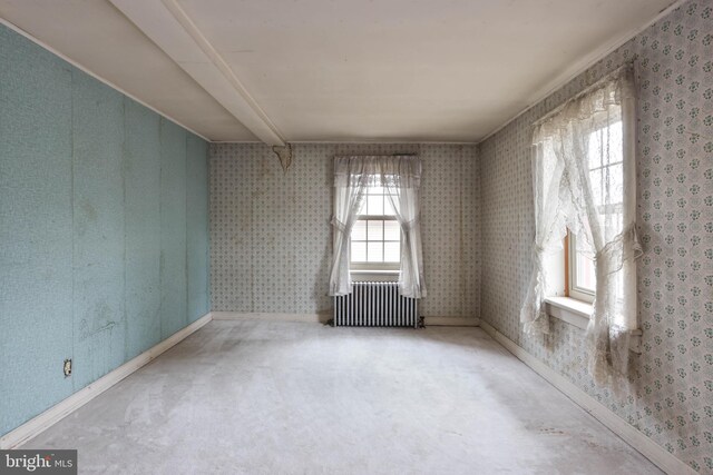 spare room featuring radiator heating unit and carpet