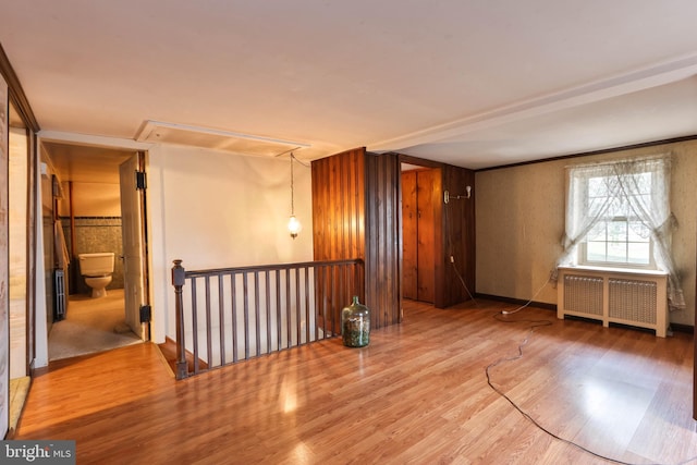 empty room featuring radiator and hardwood / wood-style floors