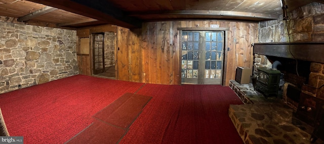 basement with wood walls, a wood stove, and wood ceiling