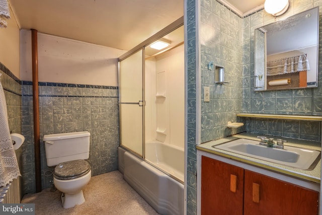 full bathroom featuring vanity, tile walls, combined bath / shower with glass door, toilet, and backsplash