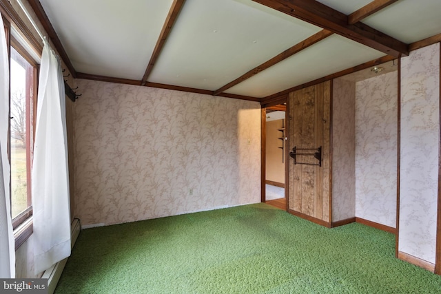 unfurnished room with beamed ceiling and carpet floors