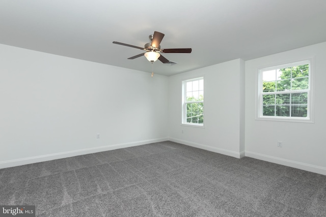 spare room with ceiling fan and dark carpet