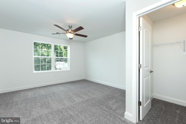 unfurnished bedroom featuring dark colored carpet and ceiling fan