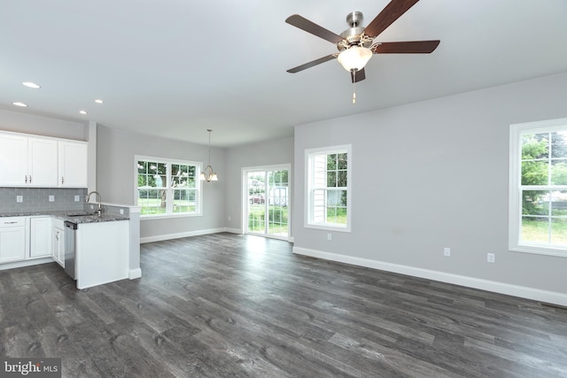 kitchen with sink, white cabinetry, backsplash, a wealth of natural light, and dark stone counters