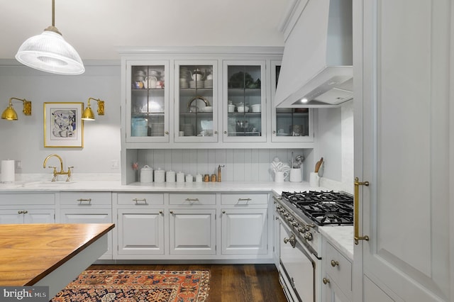 kitchen featuring pendant lighting, backsplash, gas stove, white cabinets, and custom exhaust hood