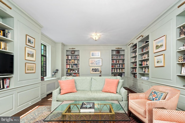 living room with dark hardwood / wood-style floors, radiator, and built in shelves