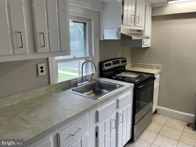 kitchen with wall chimney range hood, stainless steel range with electric stovetop, sink, and white cabinetry