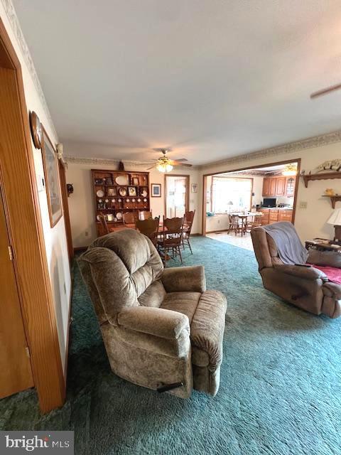 carpeted living room featuring ceiling fan