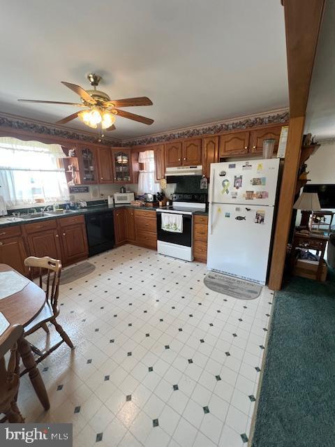 kitchen featuring electric stove, sink, ceiling fan, black dishwasher, and white fridge