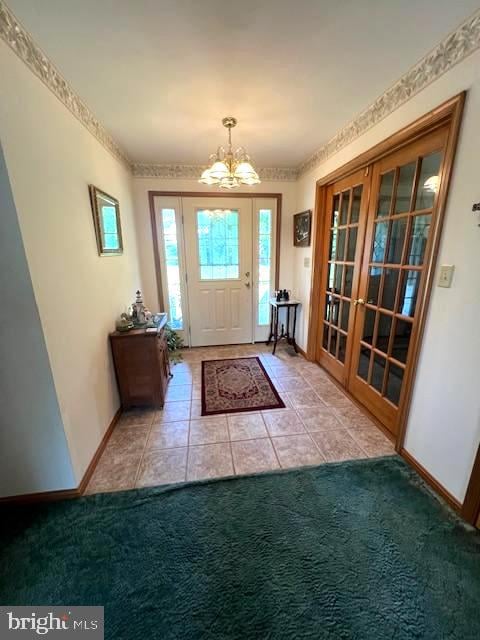 doorway with light carpet and a notable chandelier