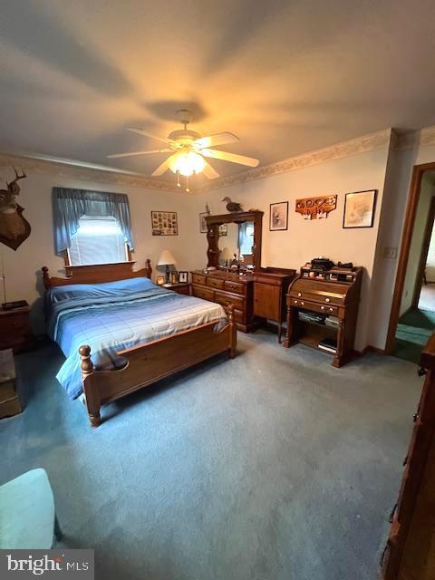 carpeted bedroom with crown molding and ceiling fan