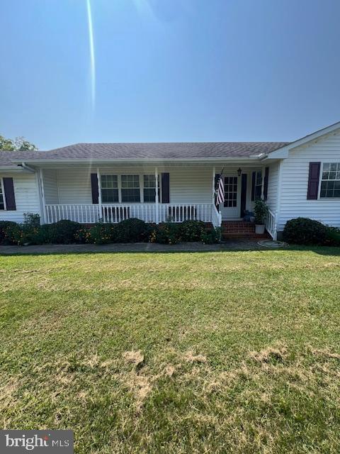 ranch-style home with a front yard and covered porch