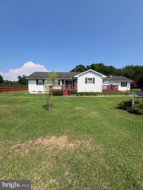 view of front of house featuring a wooden deck and a front yard