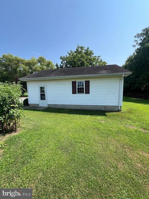 view of side of home with a yard