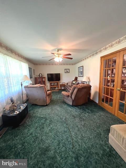 carpeted living room with ceiling fan