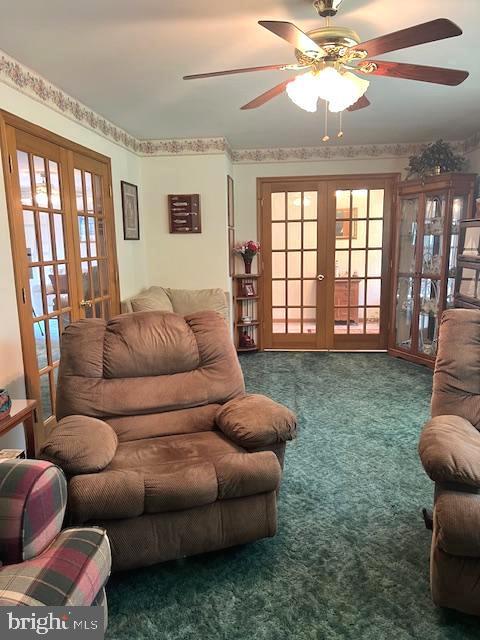 carpeted living room featuring a wealth of natural light, ceiling fan, and french doors