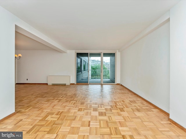 unfurnished room with expansive windows and baseboards