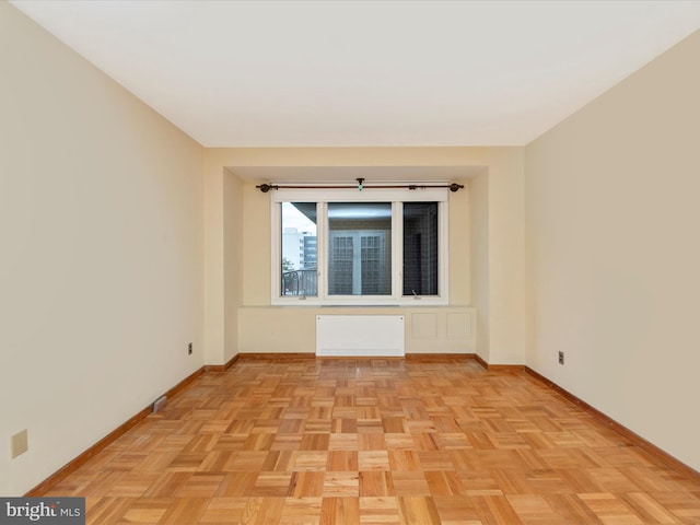 empty room with baseboards and radiator heating unit