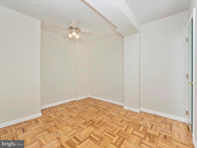 unfurnished room with ceiling fan and baseboards