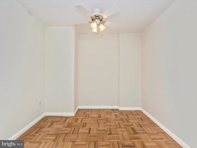 spare room with ceiling fan and baseboards