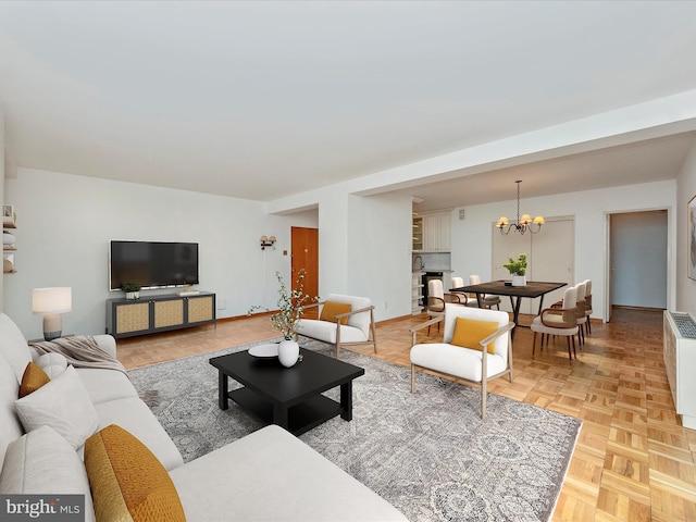 living area featuring a chandelier and baseboards