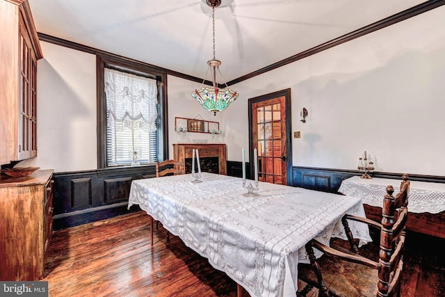 dining space with a fireplace, ornamental molding, and hardwood / wood-style floors