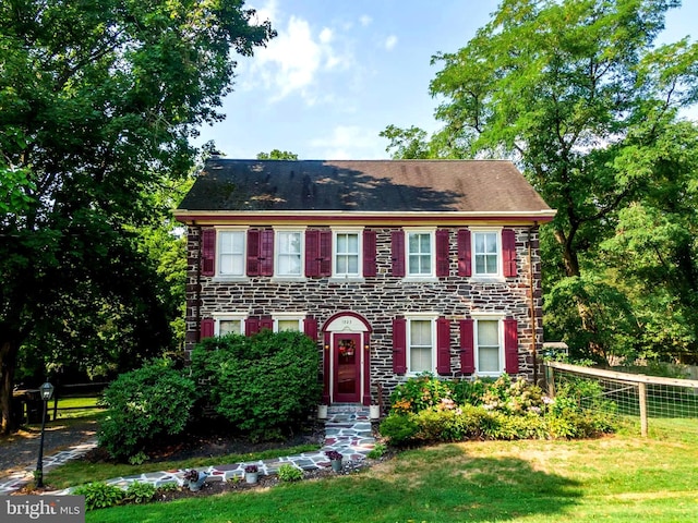 colonial house featuring a front yard