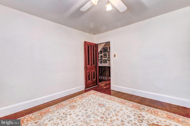 empty room with ceiling fan and dark wood-type flooring