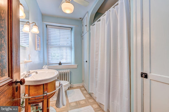 bathroom featuring radiator, toilet, vanity, and tile patterned flooring