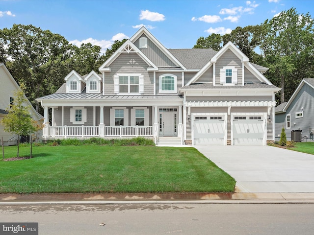 view of front of house with a garage, covered porch, a front yard, and central air condition unit