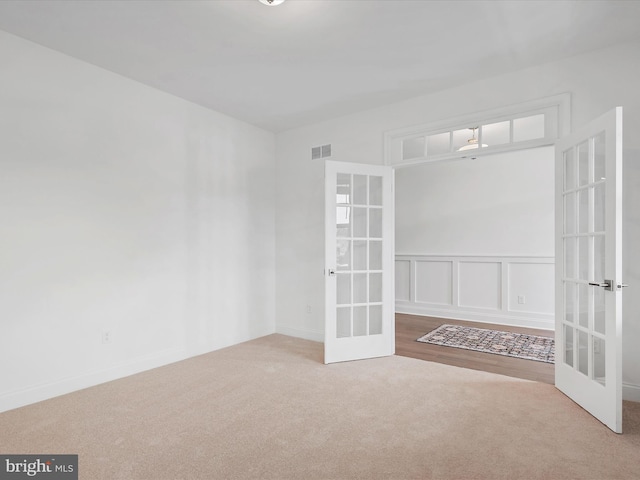 carpeted spare room with french doors