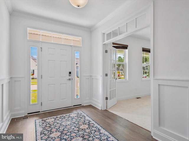 foyer featuring crown molding and dark wood-type flooring