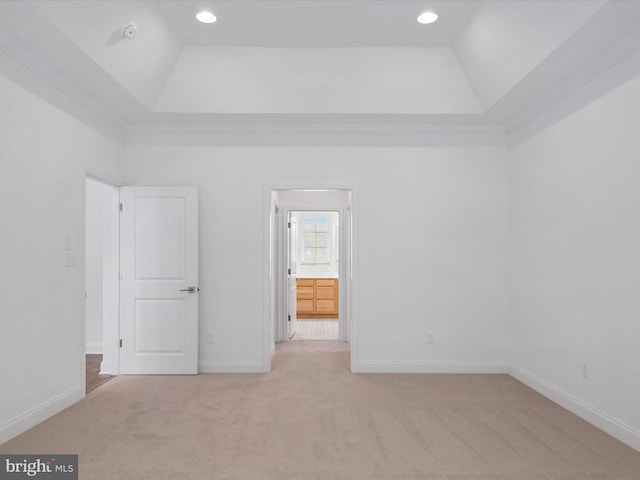 unfurnished bedroom featuring light colored carpet, a raised ceiling, and high vaulted ceiling